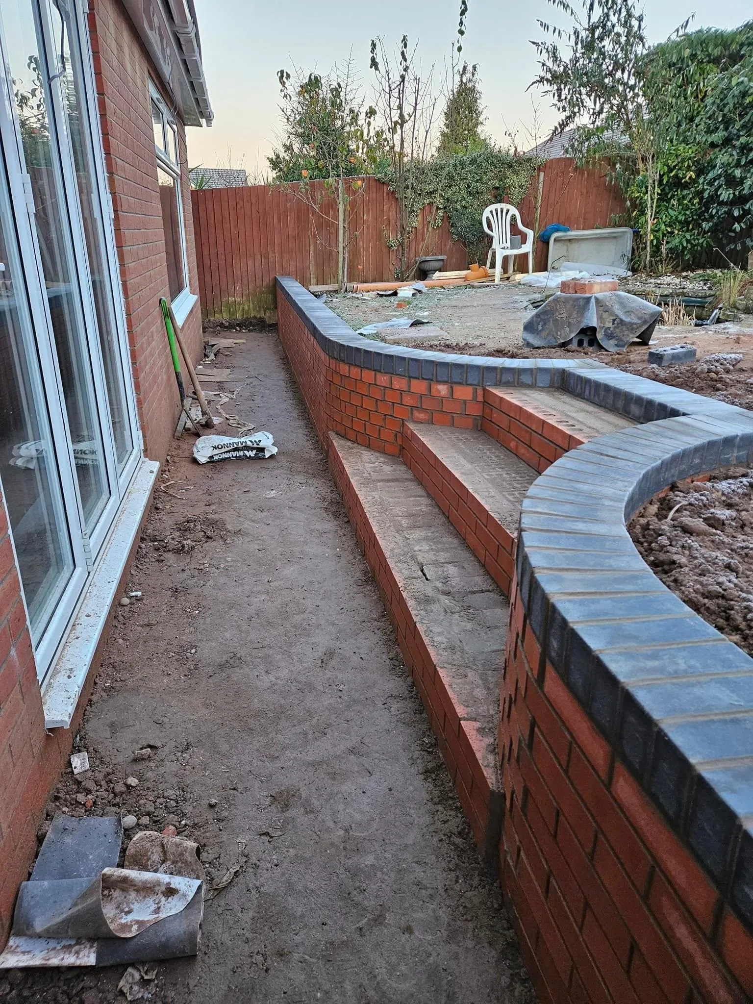 New curved brick garden walls and steps with blue coping bricks
