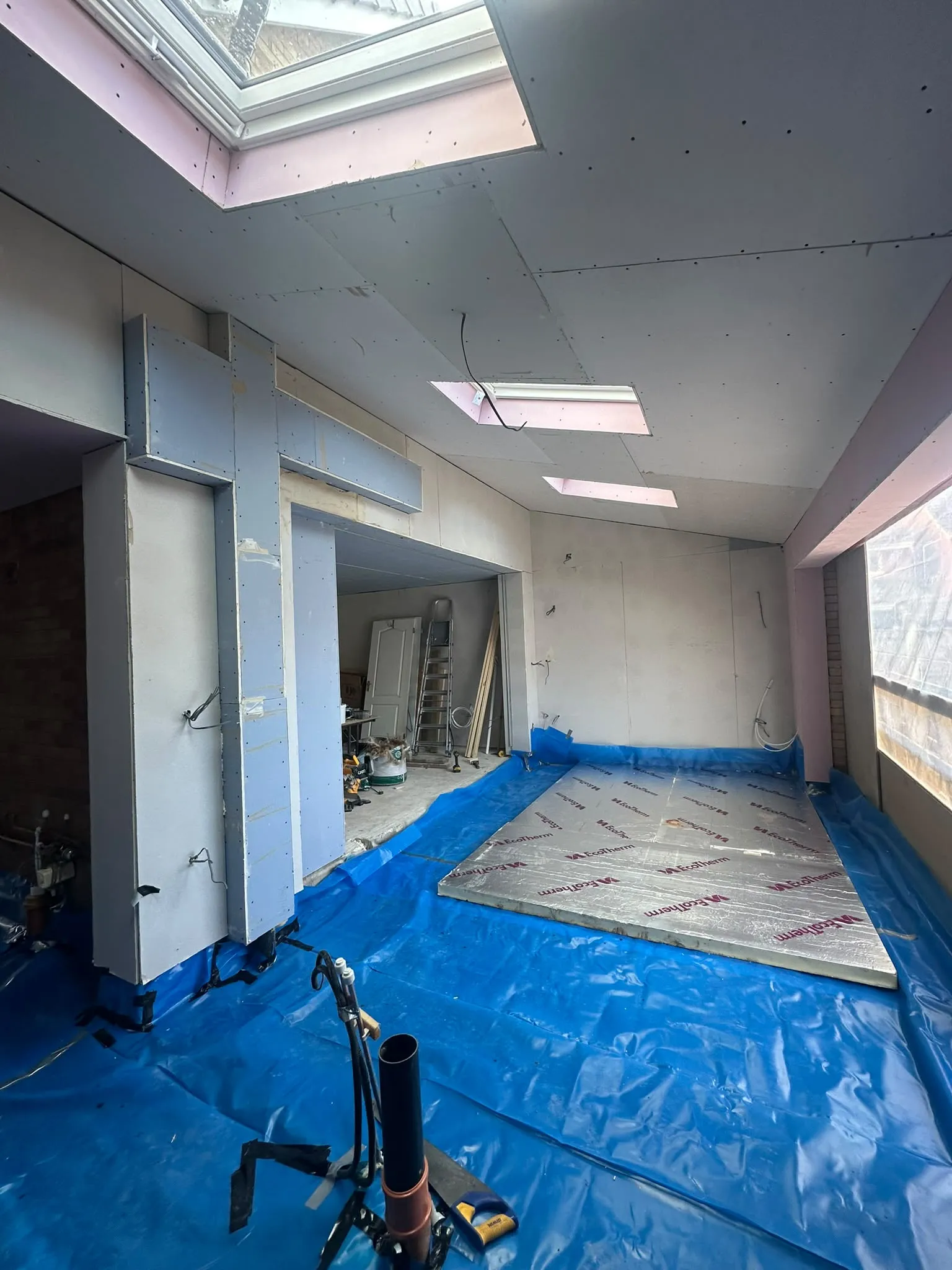 Inside a new extension before plastering, with roof windows overhead