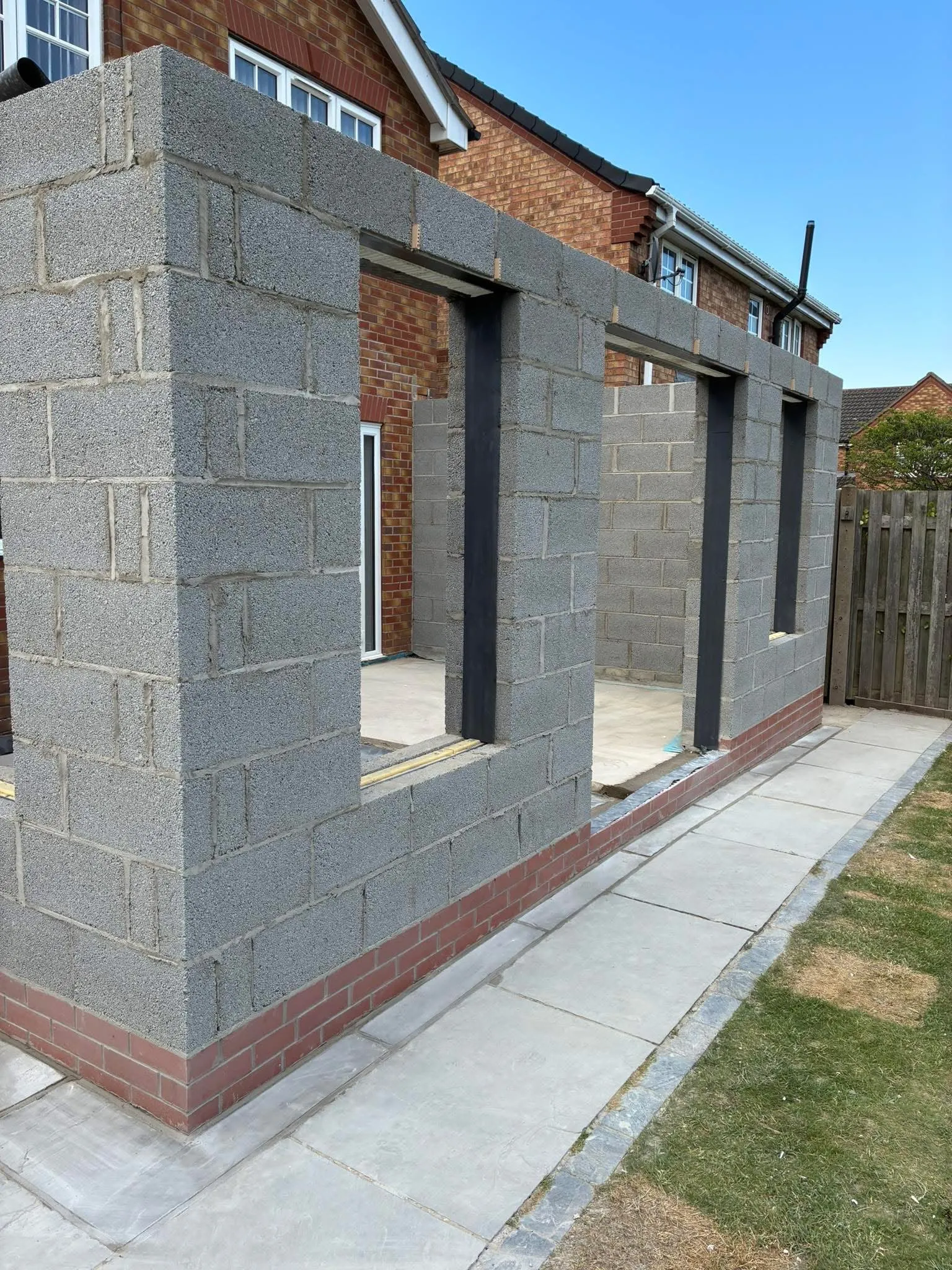 Single-storey side extension in blockwork with tall window openings