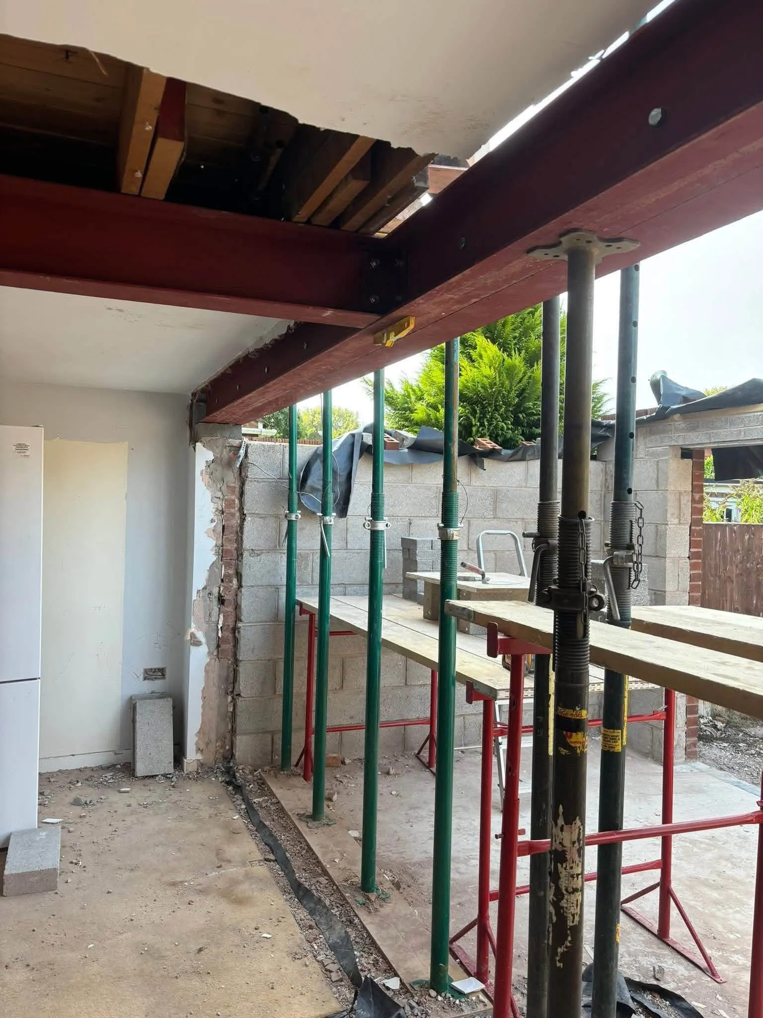 New steel beam held up on metal props where a back wall was opened