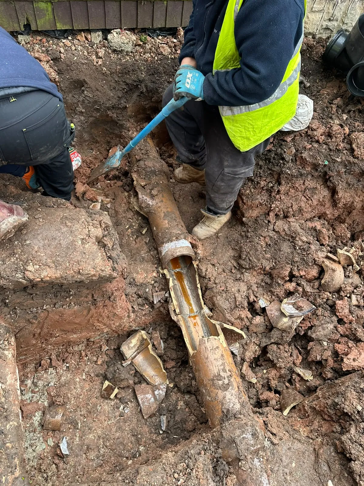 Old clay drain pipe broken open in a dug-out trench