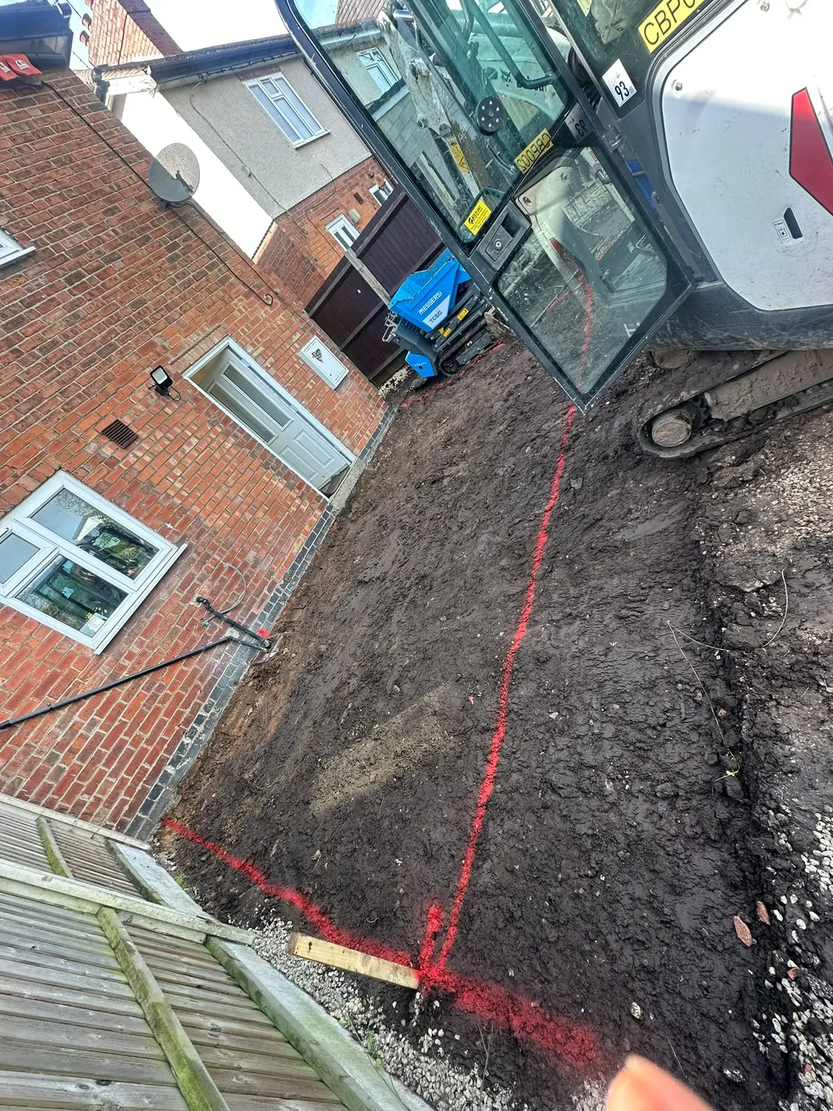 Red marker lines sprayed on the ground to show where to dig