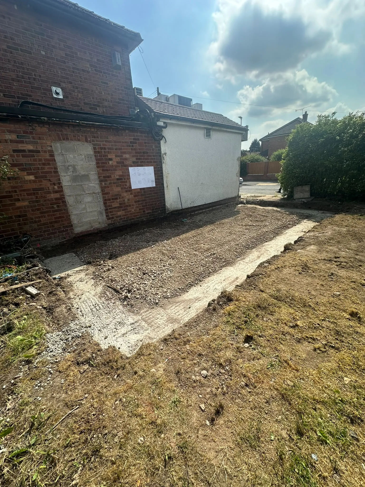 Cleared ground next to a house, edged with concrete