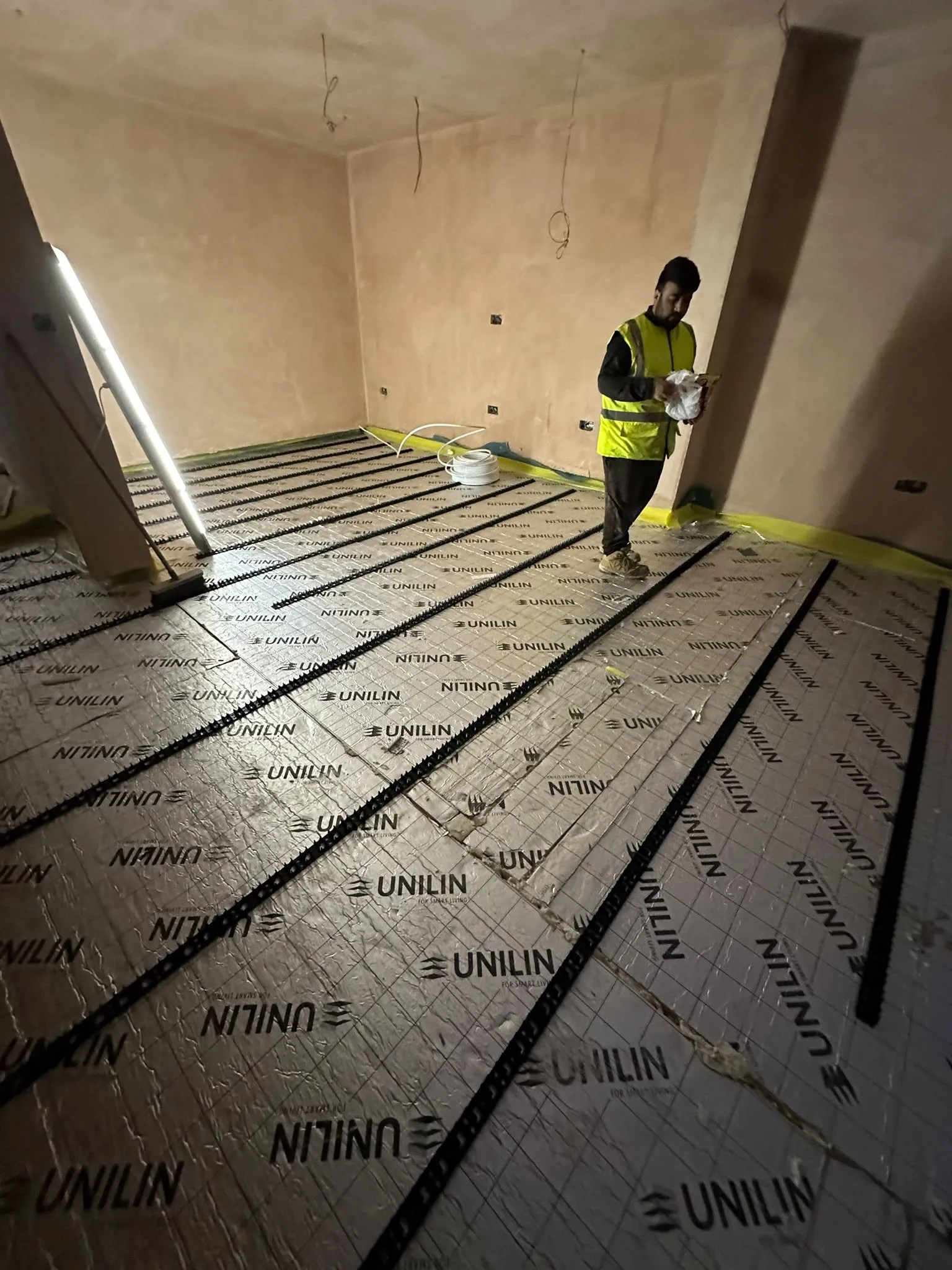Freshly plastered room with insulation boards on the floor