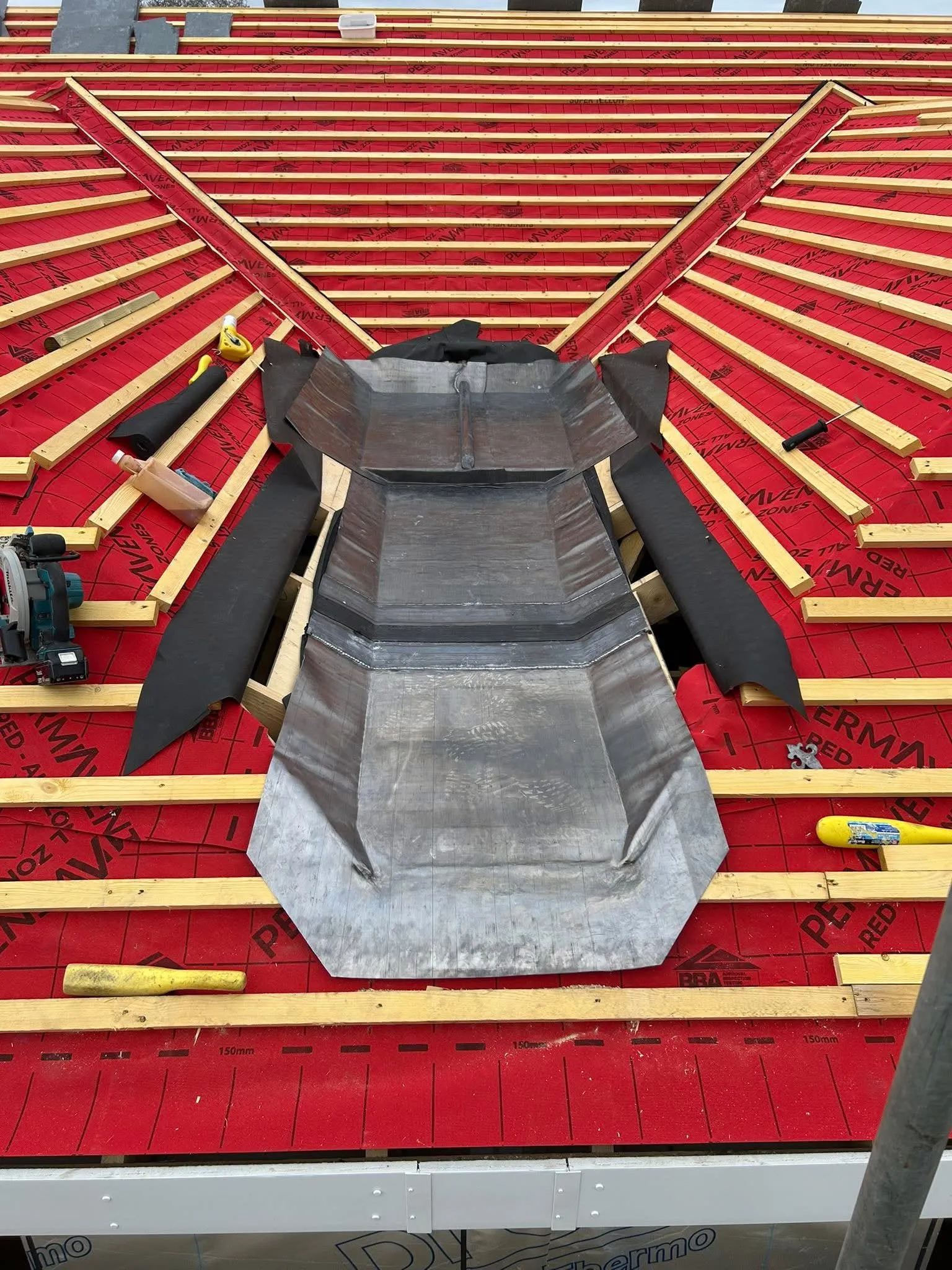 Roof with red membrane and battens and new grey metal flashing