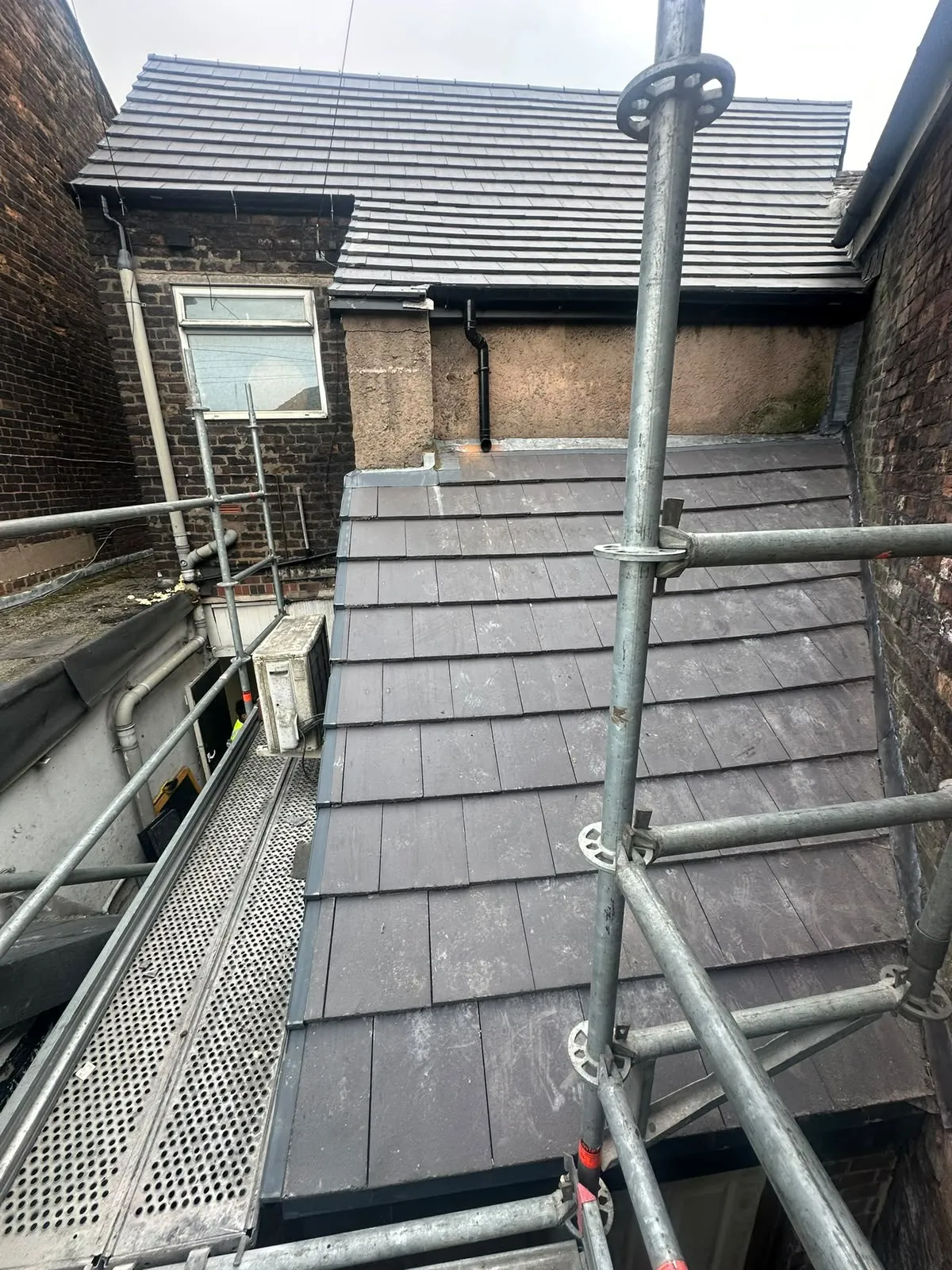 Newly tiled roof seen from scaffolding at the back of a house